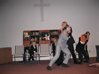 Mr. Bynoe wanting to attack Frimm and being stopped by Cramer as Archie corrals Frimm with Iris Innes knocked to the floor (only her legs are in the photo).